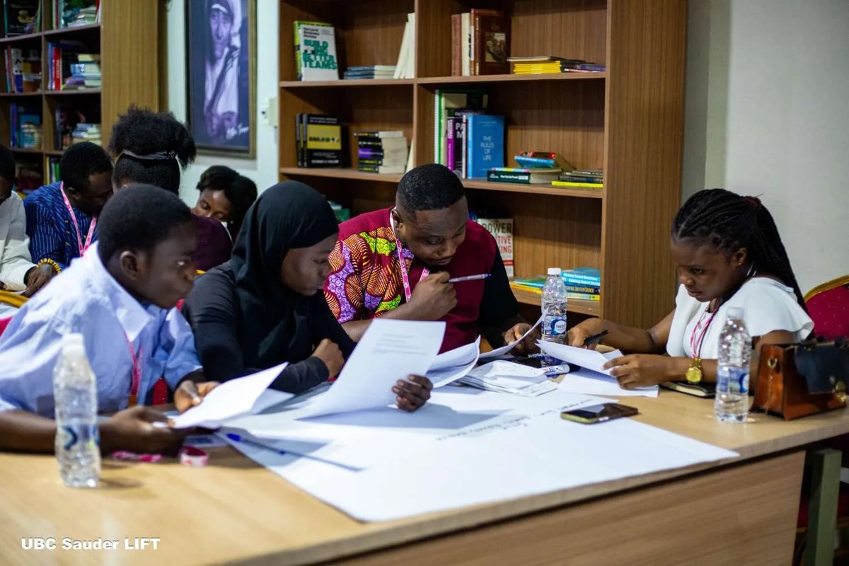 Participants writing on flip-chart paper at a training