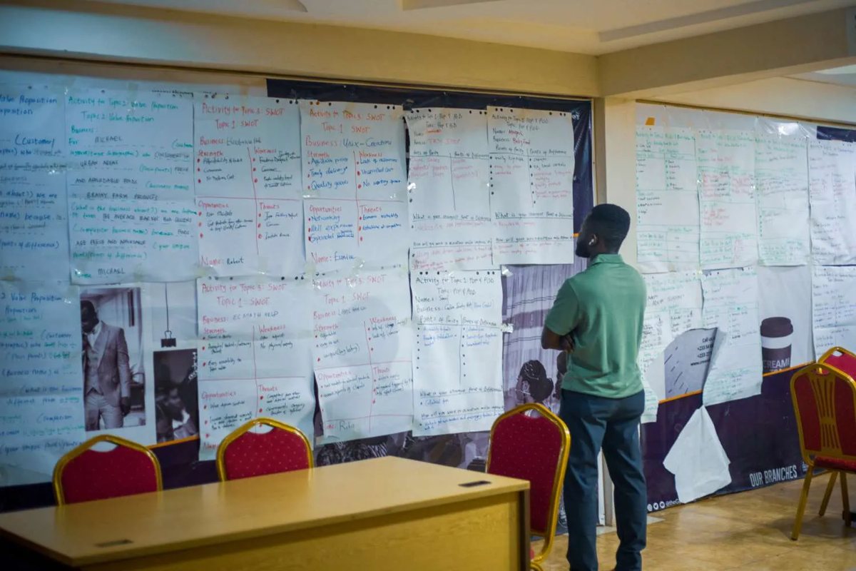 N.K. Emmanuel in front of a wall of workshop notes